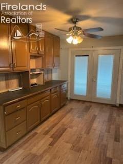 kitchen with ceiling fan, light wood finished floors, and dark countertops