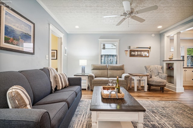 living area featuring a textured ceiling, ornamental molding, and wood finished floors