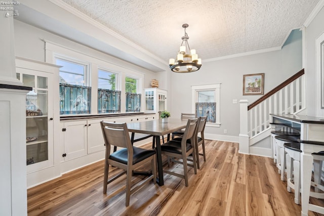 dining area with baseboards, stairway, crown molding, light wood-type flooring, and a notable chandelier