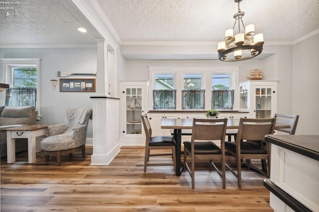 dining room with ornamental molding, light wood-type flooring, and plenty of natural light