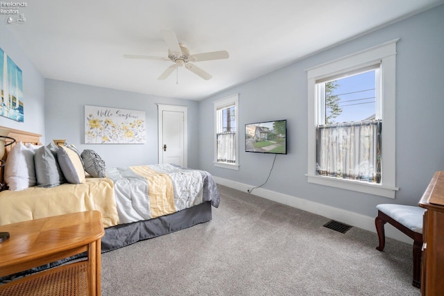 carpeted bedroom with visible vents, ceiling fan, and baseboards