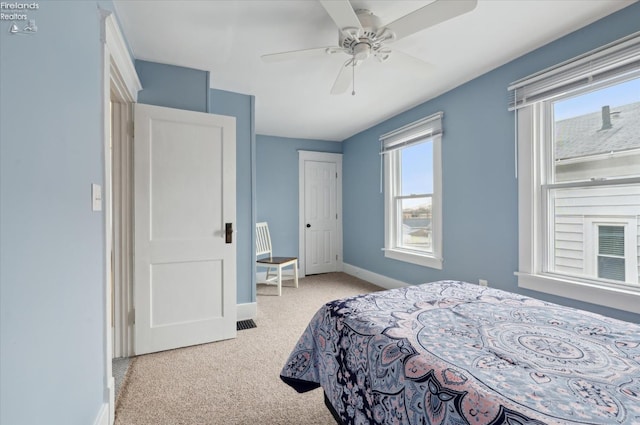 carpeted bedroom with a ceiling fan and baseboards