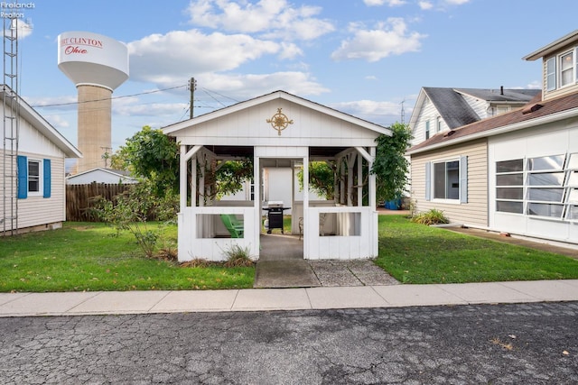 view of front of home with a gazebo, a front yard, and fence