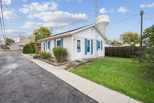 view of side of home with fence and a lawn