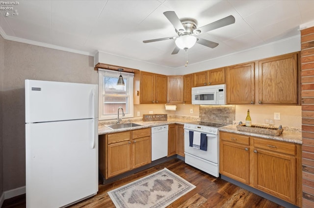 kitchen featuring white appliances, a sink, light countertops, ornamental molding, and dark wood finished floors