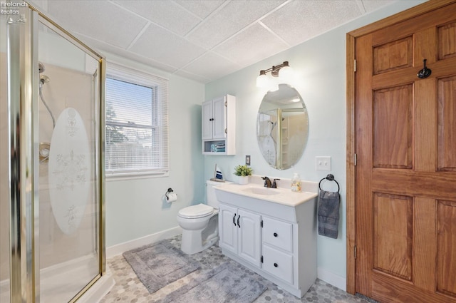 full bathroom with toilet, a shower stall, baseboards, and vanity