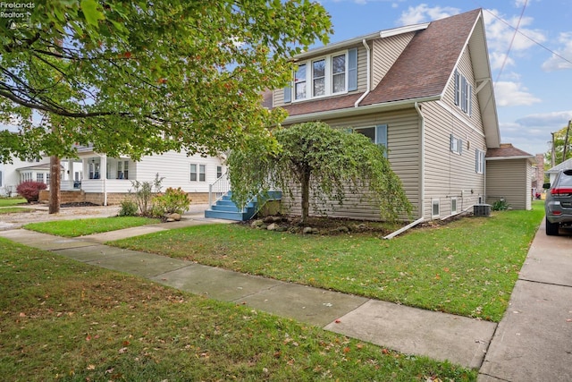 view of front of property featuring a shingled roof and a front lawn