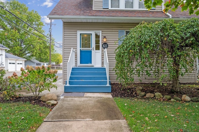 doorway to property with roof with shingles