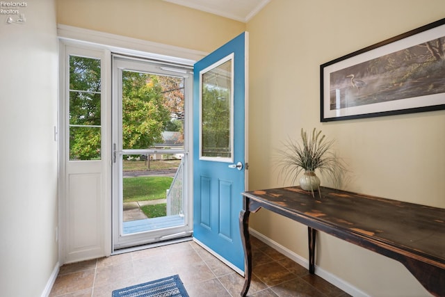 entryway with ornamental molding and baseboards