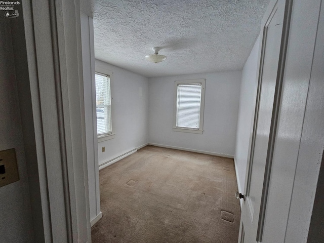 empty room featuring carpet floors, a baseboard radiator, baseboards, and a textured ceiling