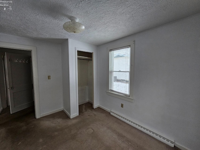 unfurnished bedroom featuring baseboards, a textured ceiling, carpet flooring, a baseboard heating unit, and a closet