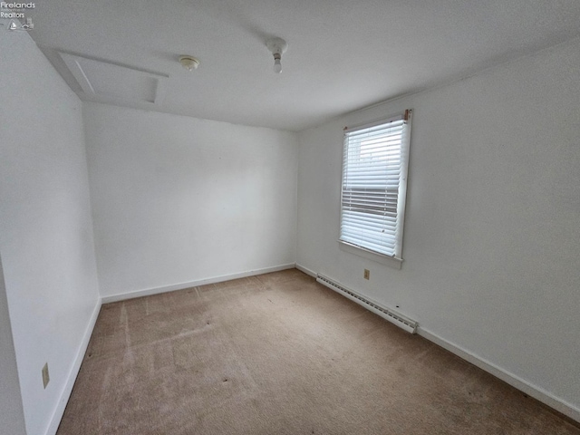 carpeted empty room with a baseboard radiator, attic access, and baseboards