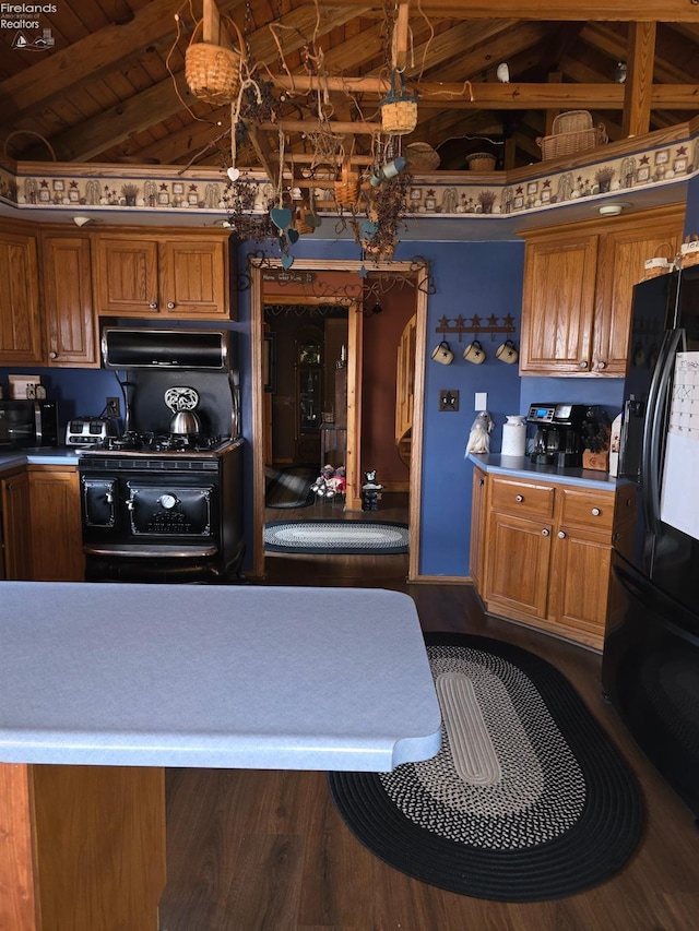 kitchen featuring brown cabinetry and lofted ceiling with beams