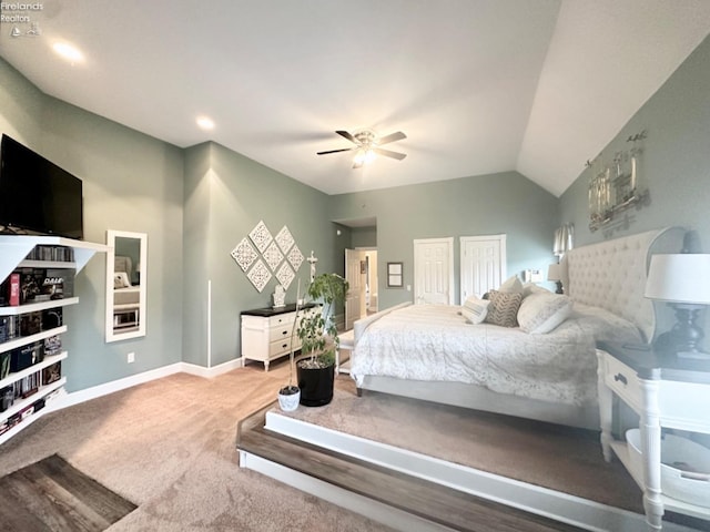 bedroom with a ceiling fan, baseboards, vaulted ceiling, multiple closets, and carpet