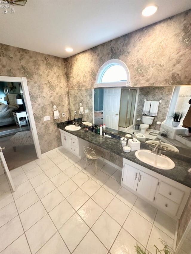 ensuite bathroom featuring connected bathroom, tile patterned flooring, and a sink