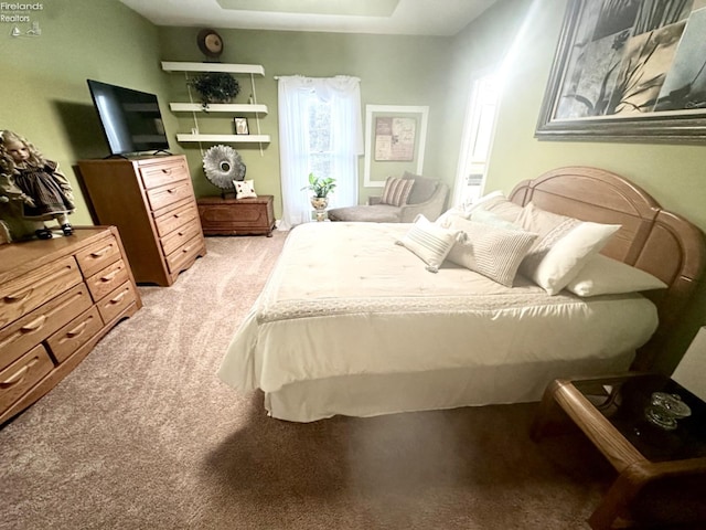 carpeted bedroom featuring a raised ceiling