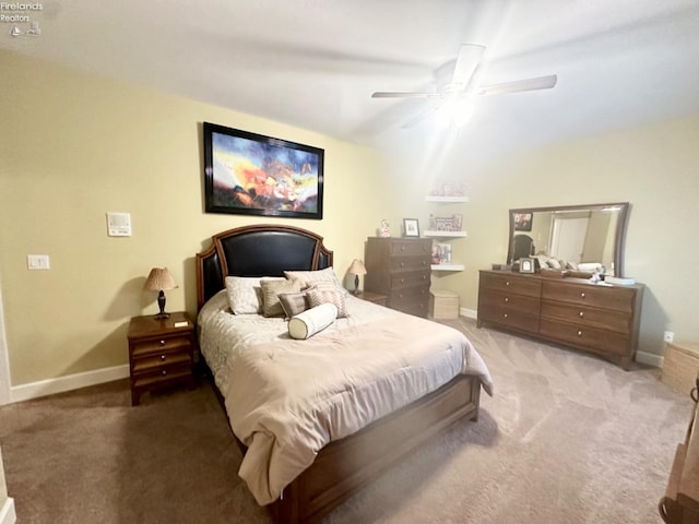 carpeted bedroom with ceiling fan and baseboards