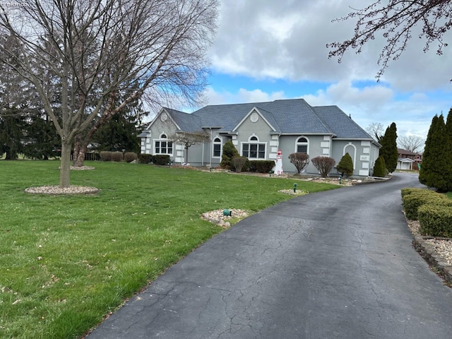 view of front of house with driveway and a front lawn