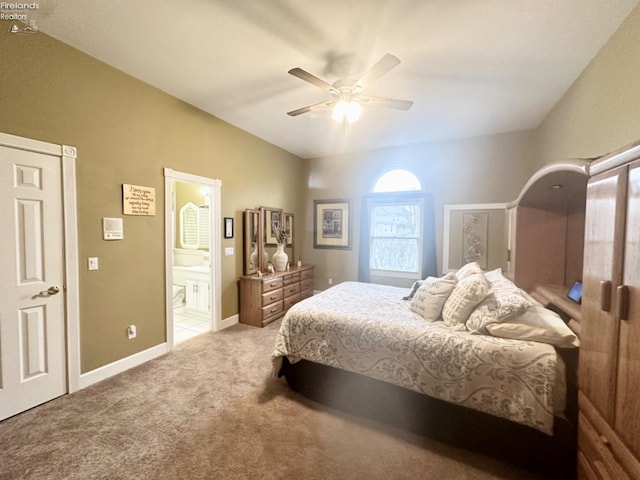 carpeted bedroom with lofted ceiling, ensuite bath, baseboards, and a ceiling fan