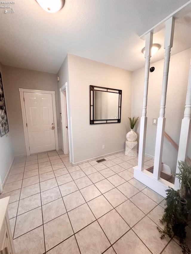 bathroom with tile patterned flooring, a textured ceiling, and baseboards