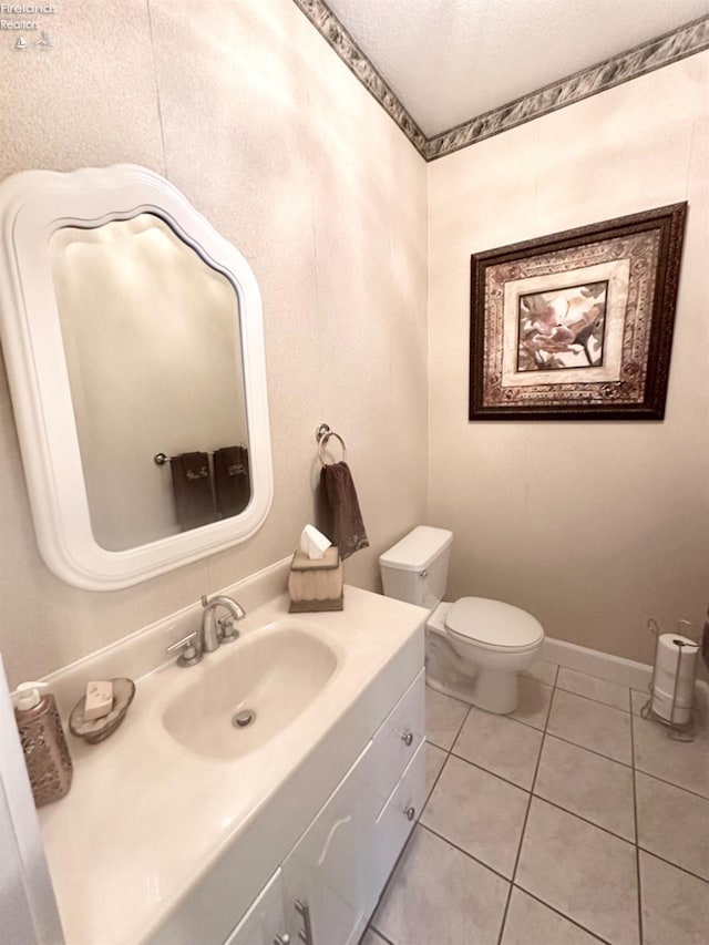 bathroom featuring toilet, a textured ceiling, vanity, baseboards, and tile patterned floors