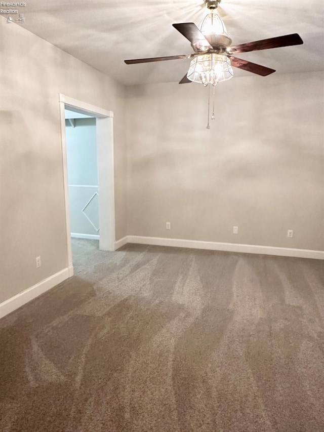 empty room featuring a ceiling fan, carpet, and baseboards