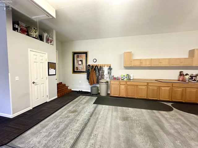 kitchen with dark wood-style floors, light brown cabinets, and baseboards