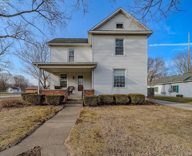 traditional-style home featuring a porch and a front yard