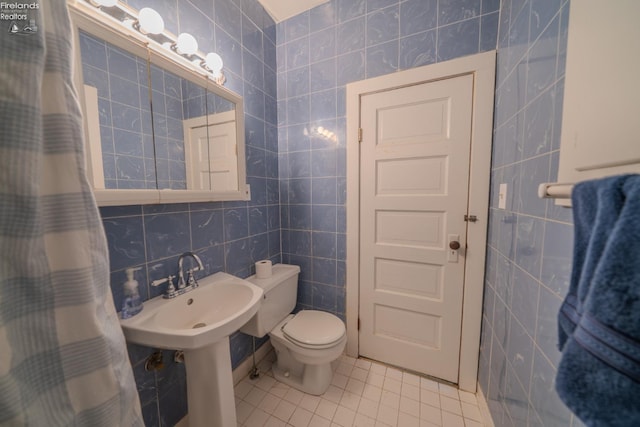 full bath with tile patterned flooring, tile walls, and toilet