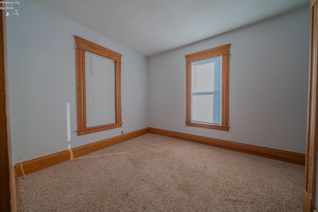 empty room with baseboards, carpet floors, and a textured ceiling