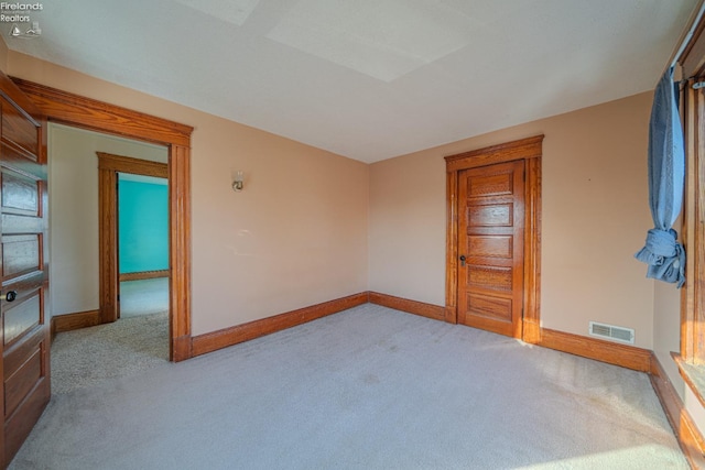 carpeted empty room featuring visible vents and baseboards