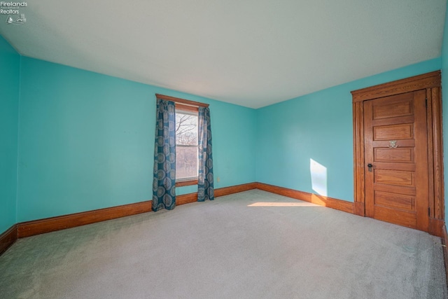 unfurnished room featuring carpet flooring and baseboards