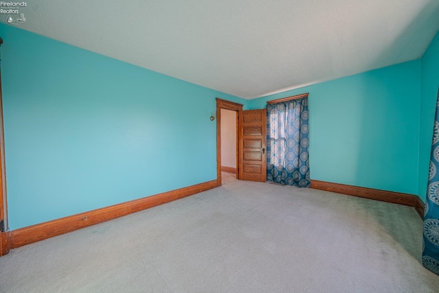 spare room with carpet and baseboards