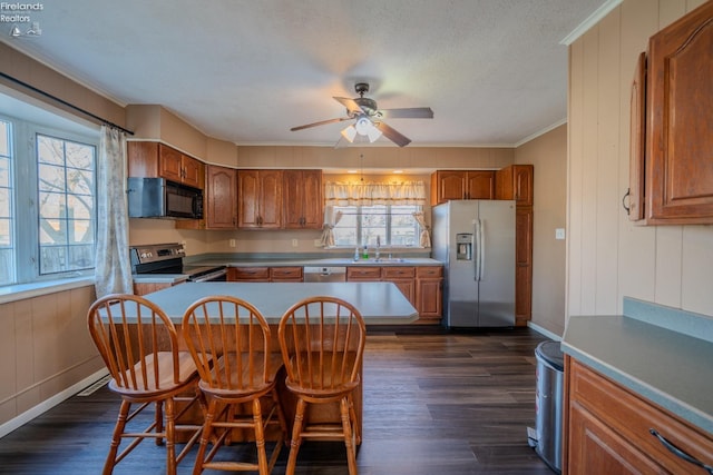 kitchen with dark wood finished floors, brown cabinets, and stainless steel appliances