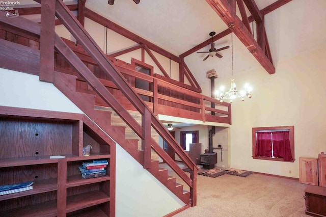 stairway with beamed ceiling, a wood stove, carpet flooring, high vaulted ceiling, and ceiling fan with notable chandelier