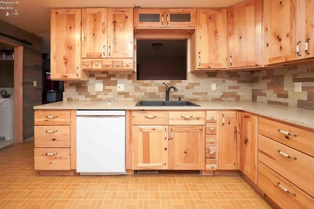 kitchen featuring dishwasher, a sink, light brown cabinets, and decorative backsplash