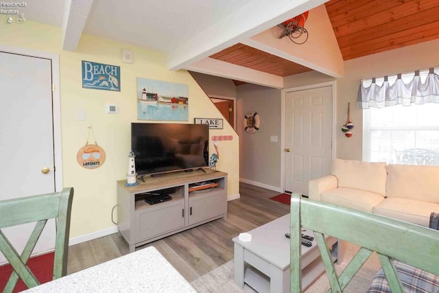 living area with lofted ceiling with beams, light wood-style floors, wood ceiling, and baseboards