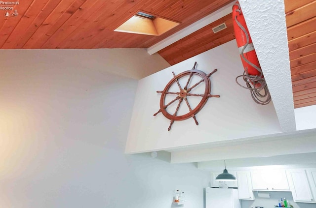 interior details featuring wooden ceiling, beamed ceiling, a skylight, and freestanding refrigerator