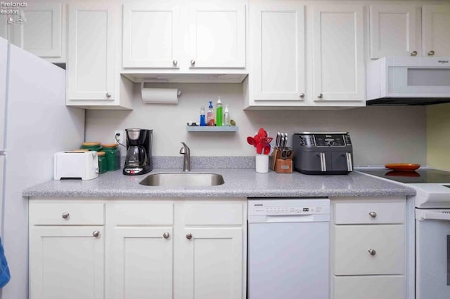 kitchen featuring light countertops, white appliances, white cabinets, and a sink