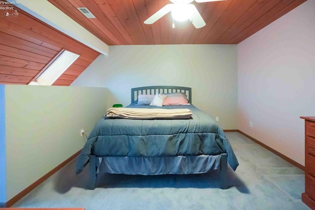 bedroom featuring carpet floors, vaulted ceiling with skylight, visible vents, and baseboards