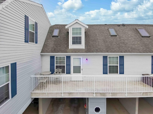 view of front of home with a shingled roof and a balcony