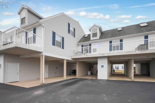 view of front of property featuring roof with shingles and driveway