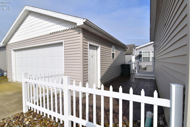 view of side of home featuring fence and an outbuilding