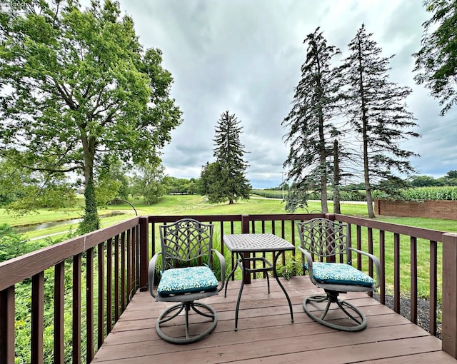 wooden deck featuring a lawn