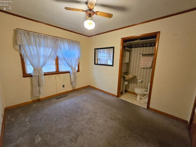 unfurnished bedroom with visible vents, a ceiling fan, connected bathroom, crown molding, and carpet flooring