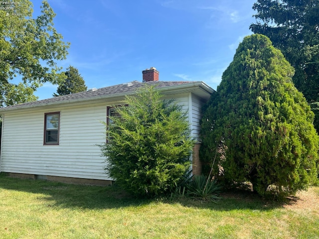 view of property exterior with a lawn and a chimney