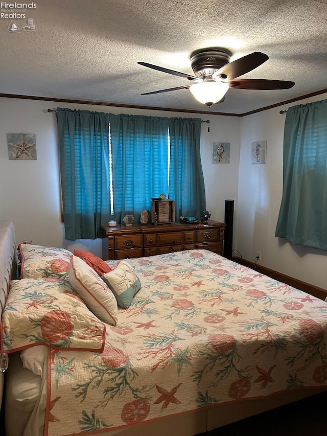 bedroom featuring a ceiling fan, ornamental molding, a textured ceiling, and baseboards