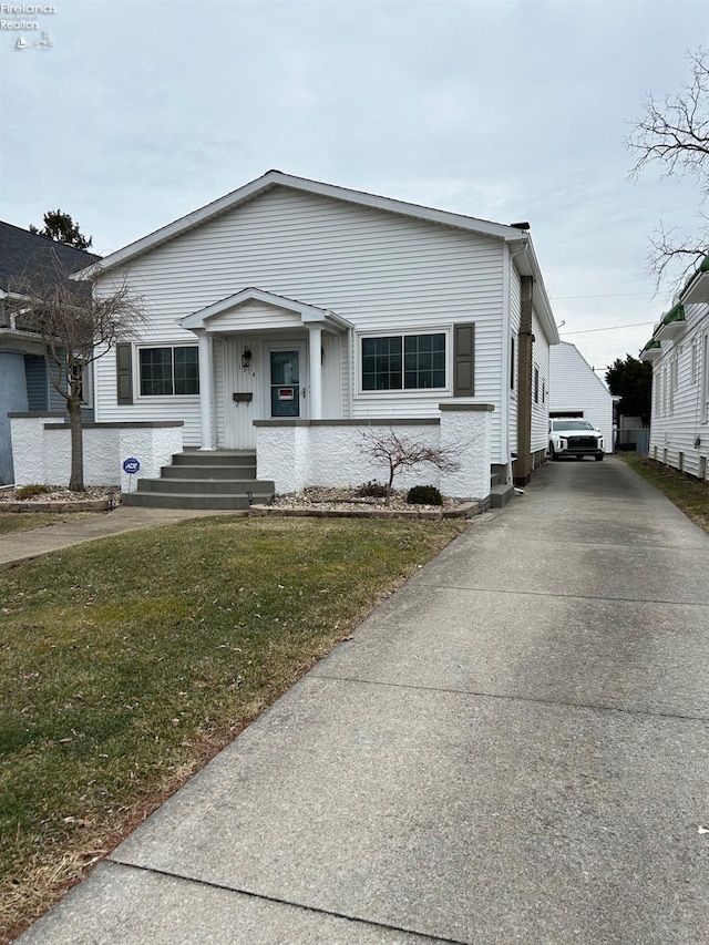 bungalow-style house featuring a front yard and an outbuilding