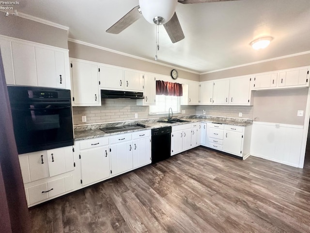 kitchen with white cabinets, a sink, under cabinet range hood, ornamental molding, and black appliances