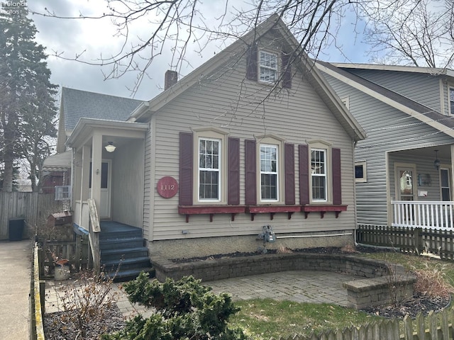 view of side of home with a chimney and fence